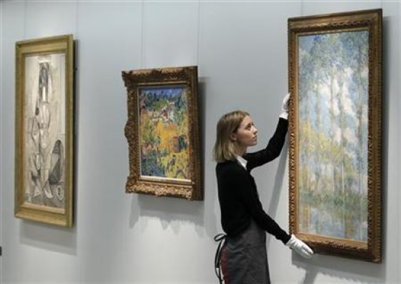 A Christie&#039;s employee poses with artist Claude Monet&#039;s &#039;&#039;Les Peupliers&#039;&#039; at Christie&#039;s auction house in London April 15, 2011.