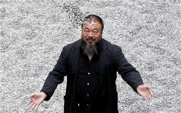 Ai Weiwei plays with his installation Sunflower Seeds, at its opening in the Tate Modern 