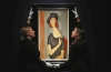 Staff pose with 'Jeanne Hebuterne (au chapeau)' from 1919 by Amedeo Modigliani at Christie's auction house in London. 