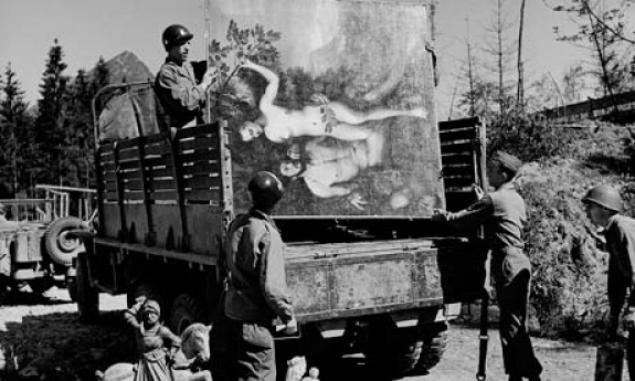 US soldiers load a truck with a painting and trinkets looted by the Nazis and found hidden in a cave.