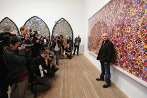 Damien Hirst being photographed at his Tate Modern exhibition in 2012.