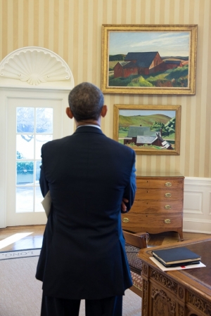 President Barack Obama looks at the Edward Hopper paintings now displayed in the Oval Office.