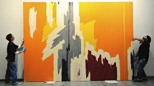 Michael Chavez, left, and Chris Perez adjust a painting, “PH-972” (1949), at the Clyfford Still Museum in Denver.