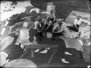 Pablo Picasso and scene painters sitting on the front cloth for Parade (Ballets Russes).